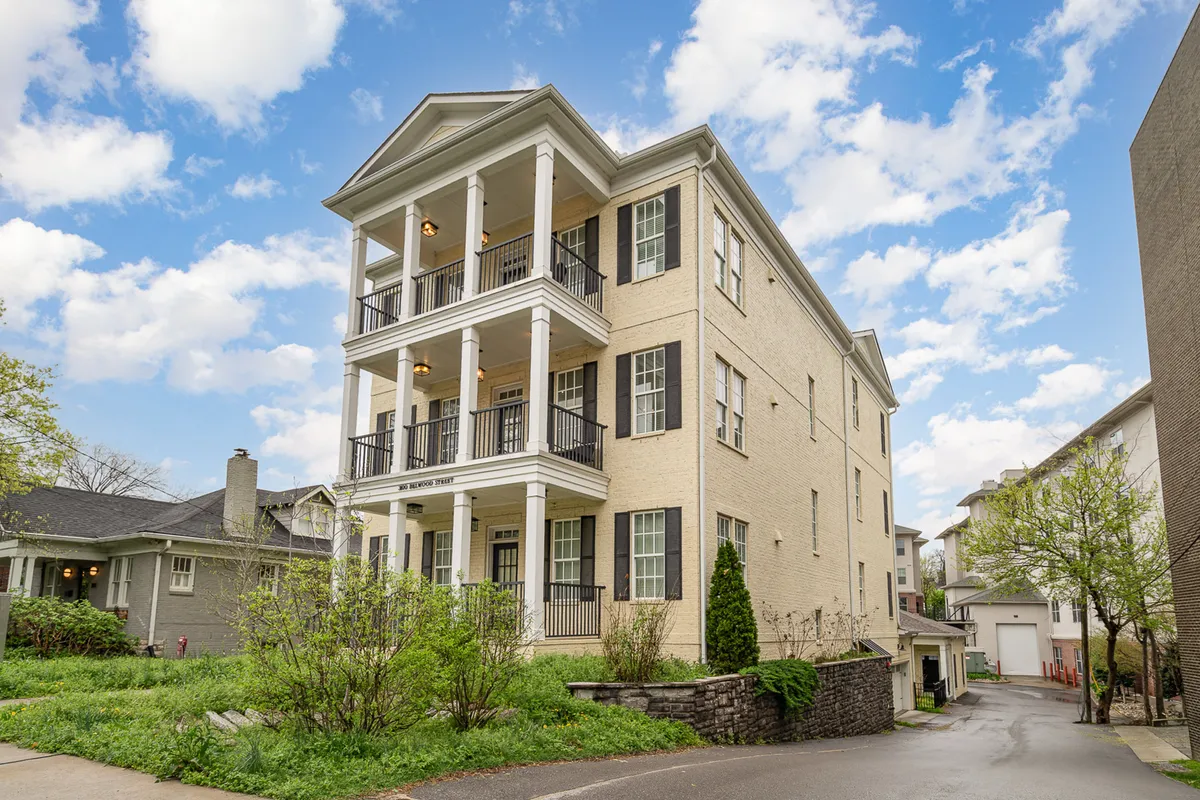 This image captures the exterior of the property, featuring a three-story structure with balconies and a landscaped garden. The scene is bright, inviting, and offers a visual sense of the scale and layout of Belwood Bloom, clearly illustrating the connected yet private setup of the units.