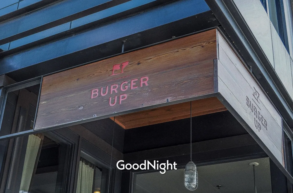 Exterior of 'BURGER UP,' featuring its welcoming signage and hanging lights, suggesting a casual and inviting dining experience. The image captures the excitement of enjoying a meal out with friends or family.