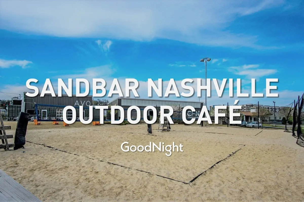 This photo features an outdoor café seating area, a sand volleyball court, and the building's exterior. The lively scene is ideal for pet-friendly dining and outdoor activities, aligning with the section's mention of nearby cafés and social spots accessible with pets.