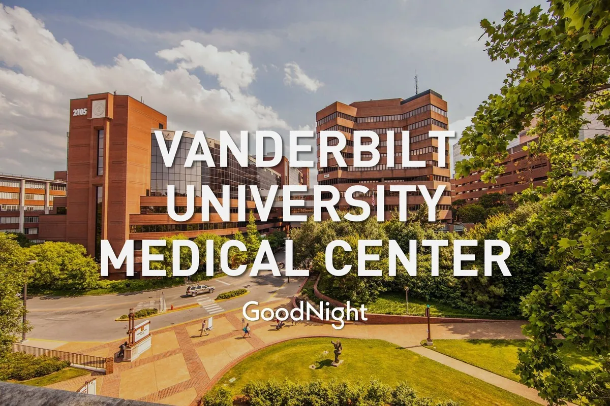 The exterior of the Vanderbilt University Medical Center building is surrounded by green spaces and pathways, with sculptural features adding visual interest. The modern structure highlights the area’s professional and academic atmosphere.